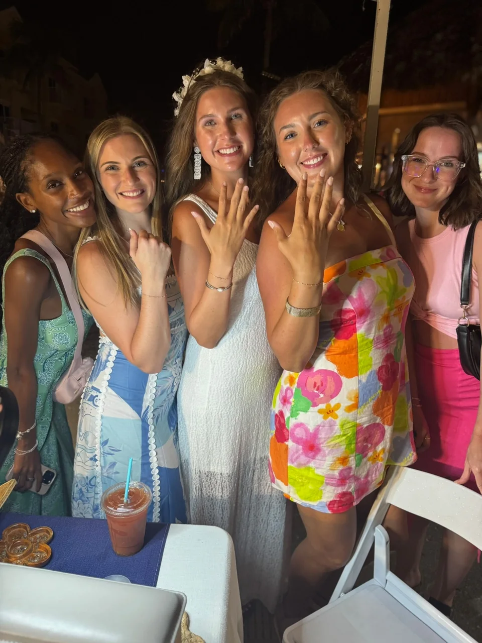 A bridal party celebrating together, showing off their gold permanent bracelets and rings