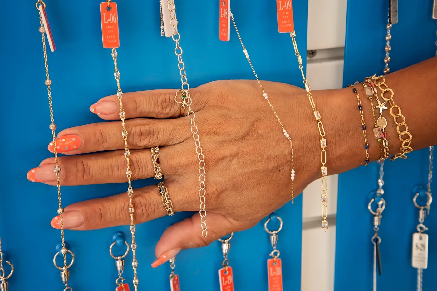 Gold-filled chains and stacking rings held across a hand to compare styles at the I Shine kiosk