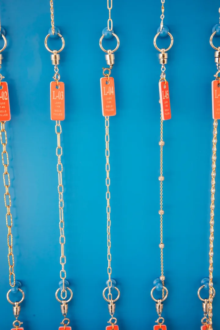 Numbered 14k gold-filled Luxe chain options hanging on the I Shine display wall