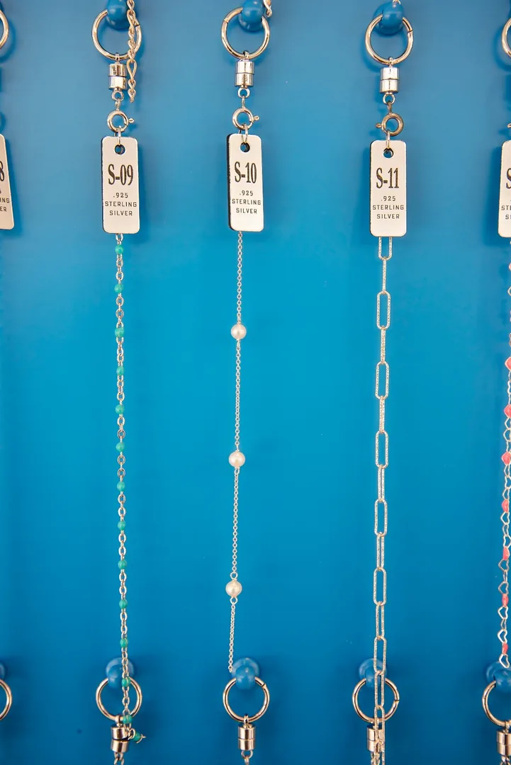 Sterling silver chain options with numbered tags on the I Shine selection wall