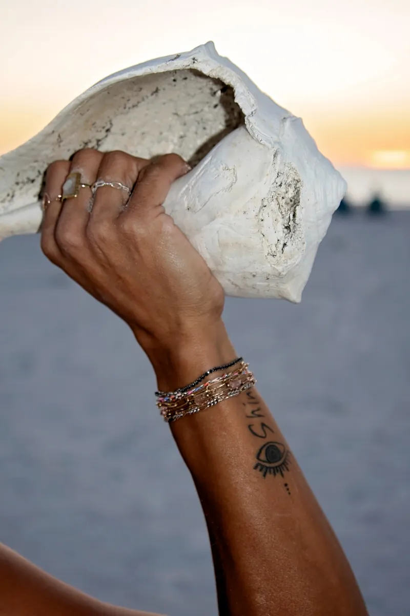 Stacked mixed-metal permanent bracelets on a forearm