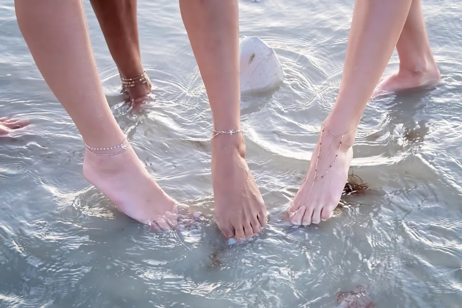 Anklets visible through shallow ocean water