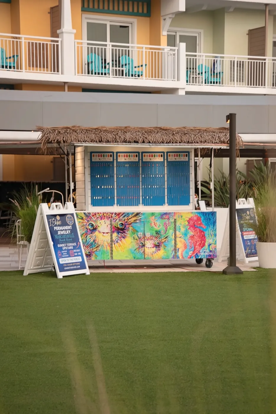 The I Shine Permanent Jewelry kiosk with its tiki roof and painted seahorse counter on the Sunset Terrace at Margaritaville Beach Resort Fort Myers Beach